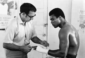 Muhammad Ali getting his hands wrapped by trainer Angelo Dundee before training session at the 5th Street Gym.  Miami Beach, Florida 10/9/1970 (Image # 2045 )